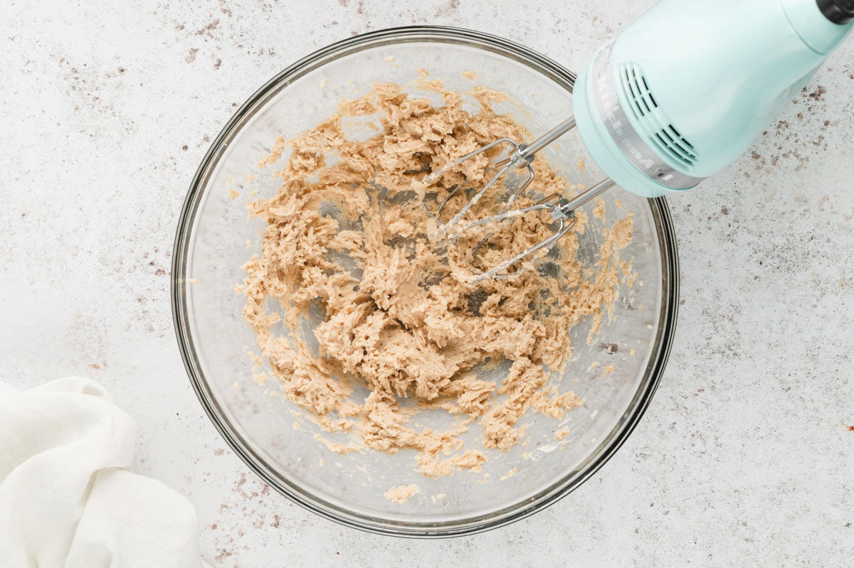 Creaming together butter and sugar in a bowl iwth a hand mixer.