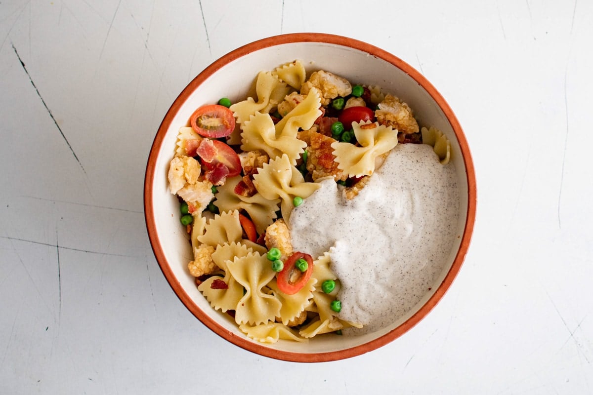 Ranch dressing poured over a combination of pasta, tomatoes, peas and chicken.