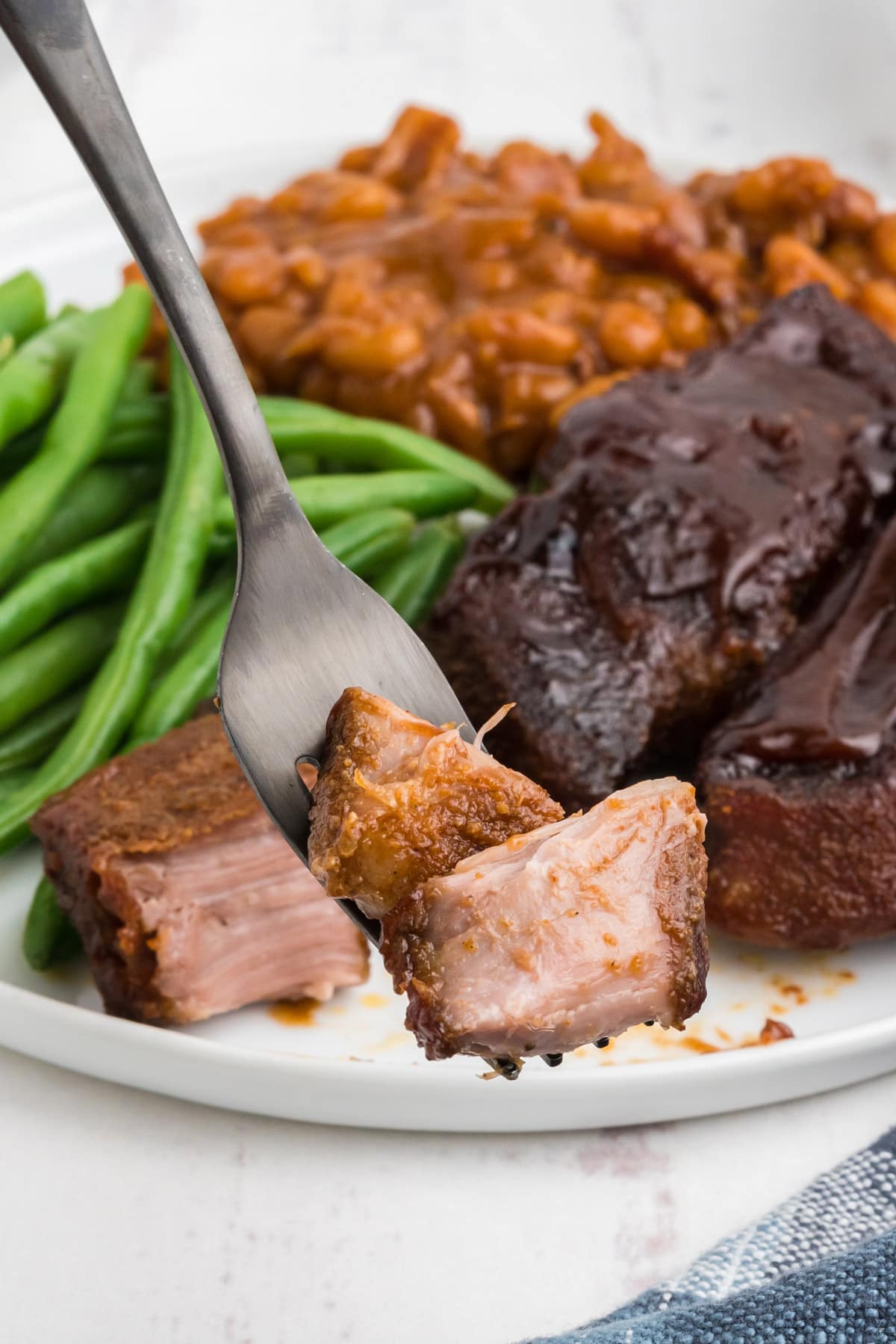 Chunks of bbq pork shoulder ribs on a fork.