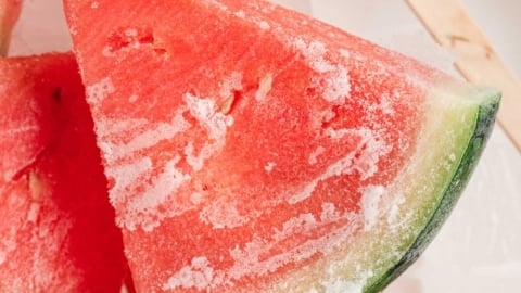 Slice of frozen watermelon with a popsicle stick.