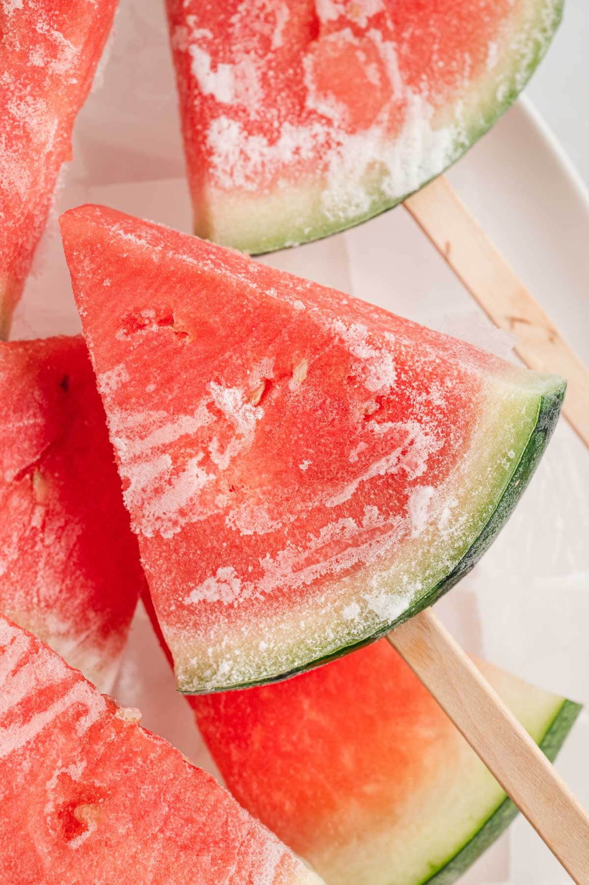 Slice of frozen watermelon with a popsicle stick.