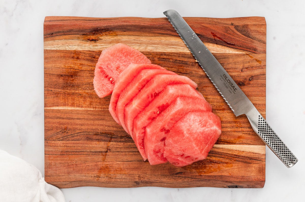 Half of a watermelon with no rind cut into slices.