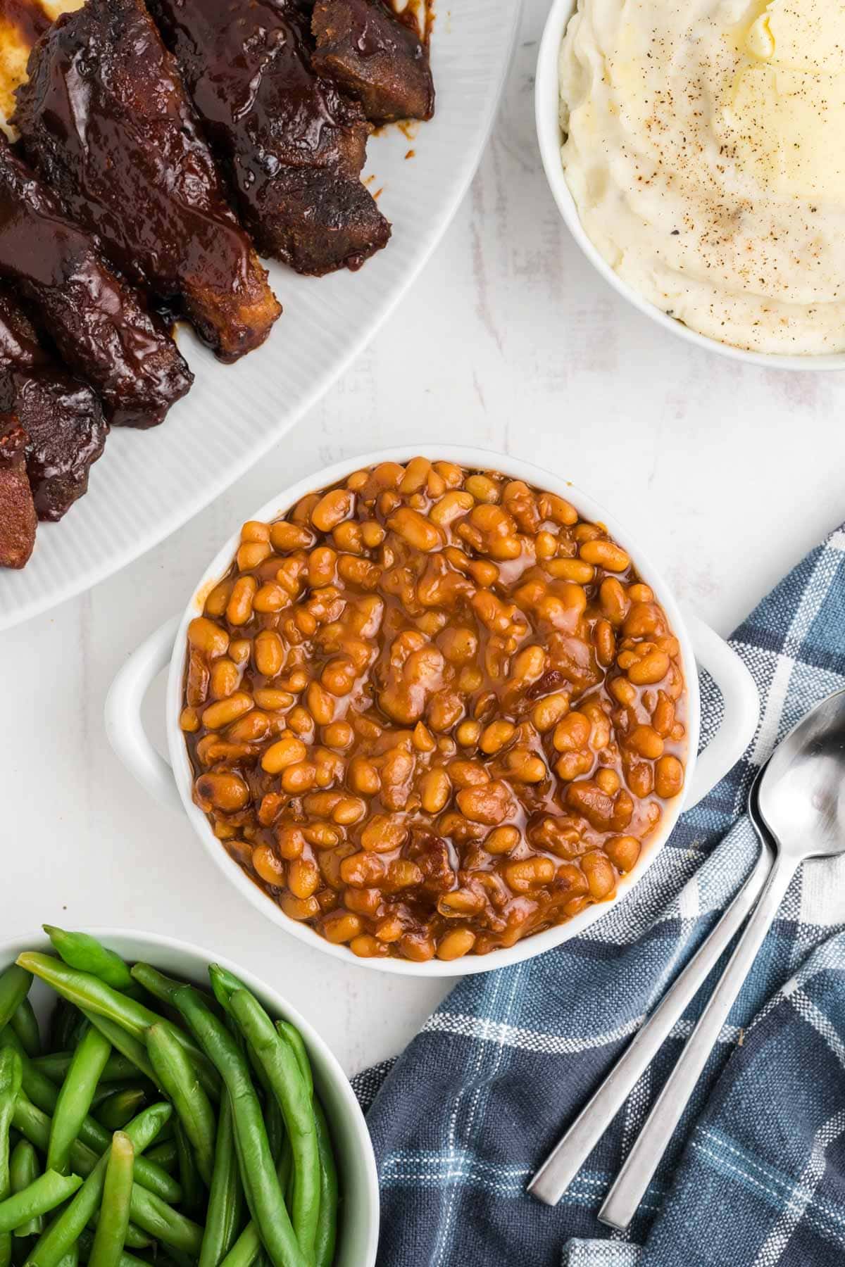 Baked beans in a small white serving bowl.