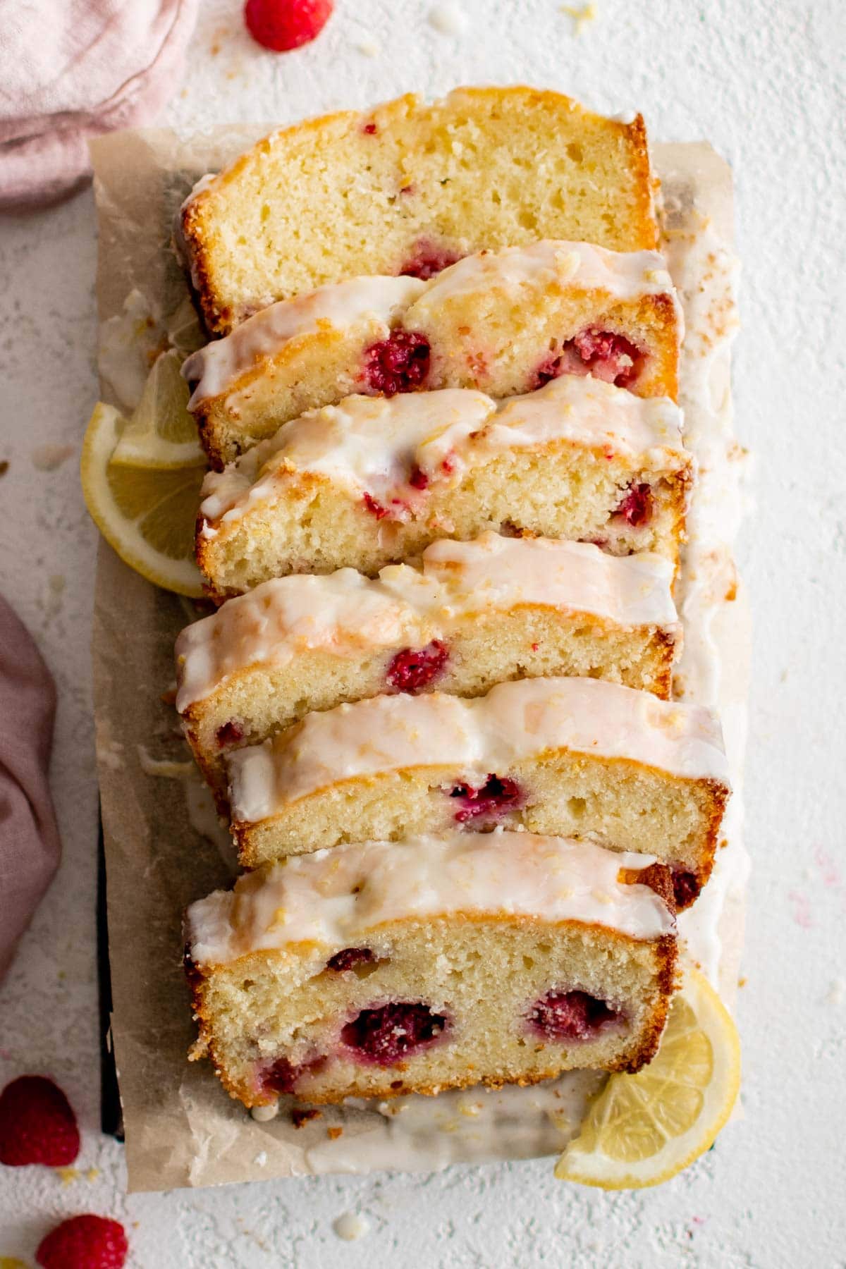 Lemon bread with raspberries and icing, sliced into 6 pieces.