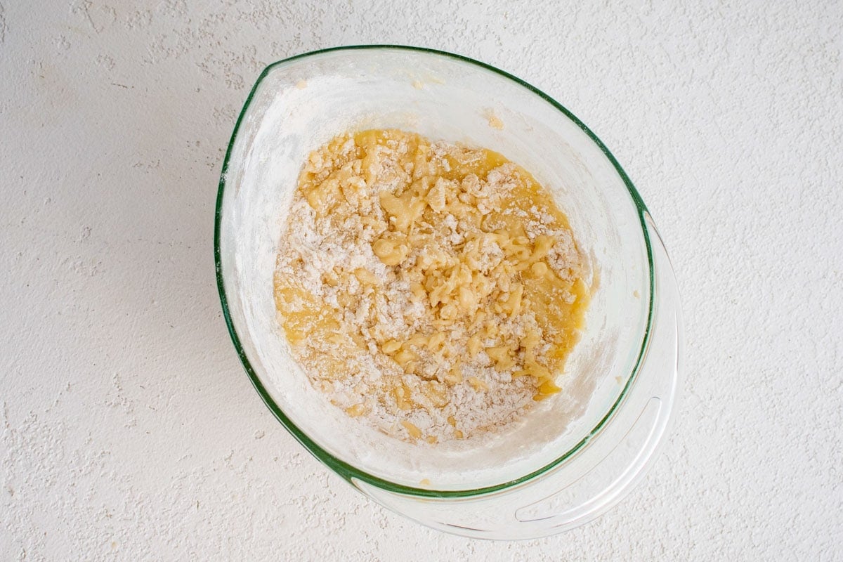 Mixing bread ingredients together in a mixing bowl.