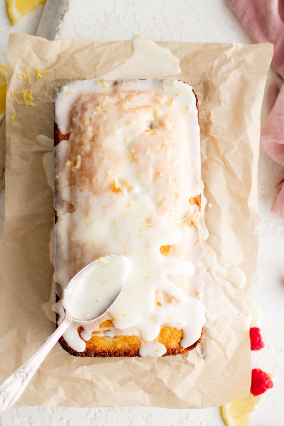 Spooning icing onto a loaf of quickbread.