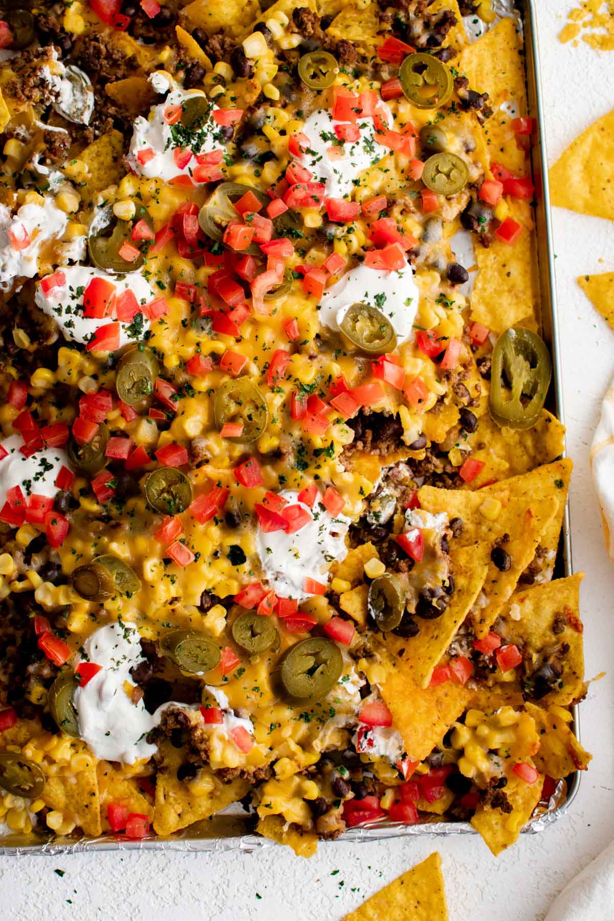 Nachos with chips, cheese, beef, sour cream, tomatoes and jalapenos