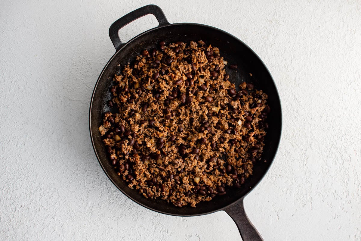 Ground beef cooked in a cast iron skillet.