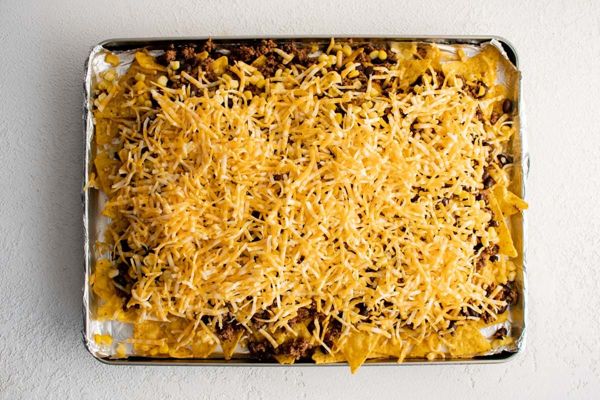 Shredded cheese layered over ground beef and tortilla chips.