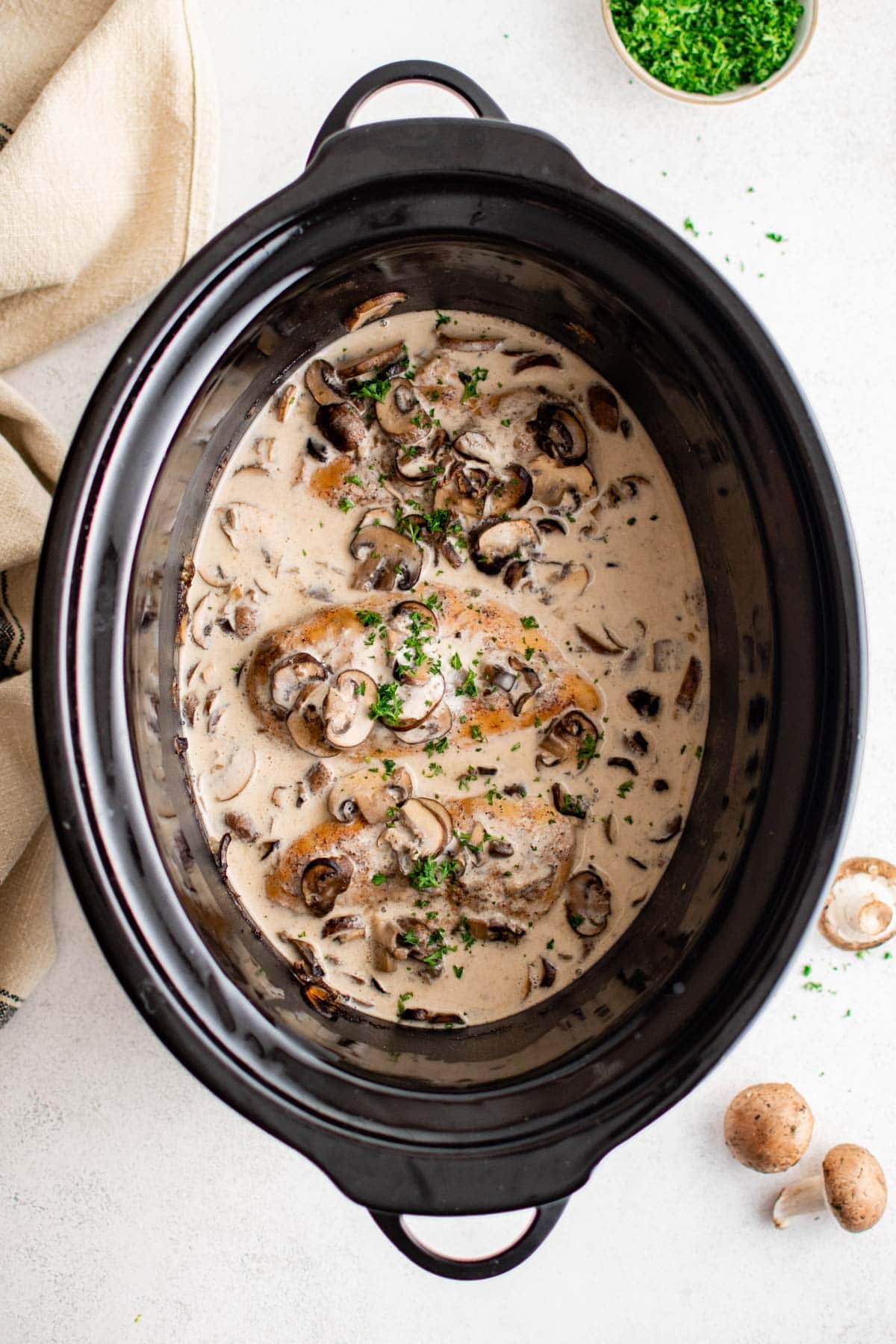 Chicken in a slow cooker with mushrooms and gravy.