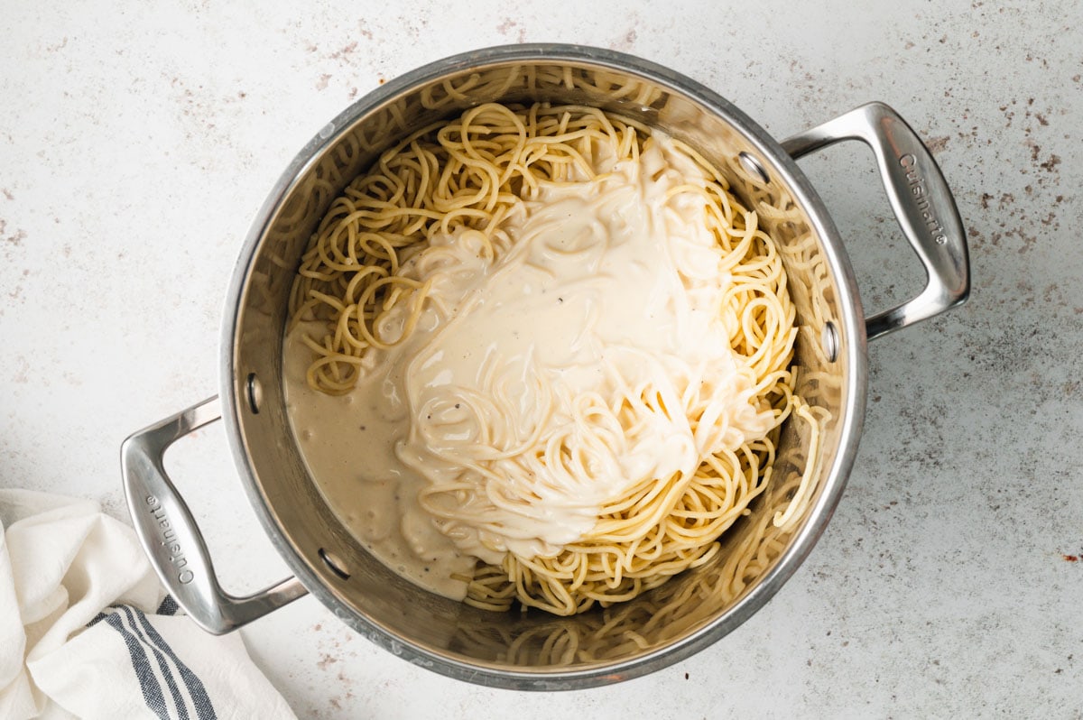 Spaghetti and cheese sauce in a saucepan.