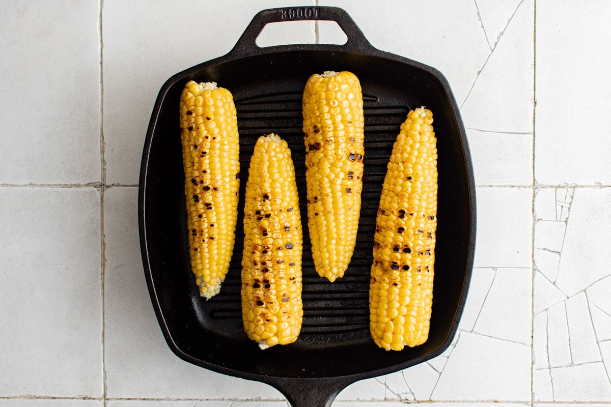 Corn on the cob with char marks on an indoor grill.