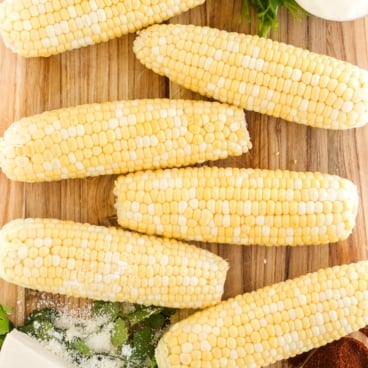 how to cook corn on the cob social media - cobs of corn on a wooden cutting board.