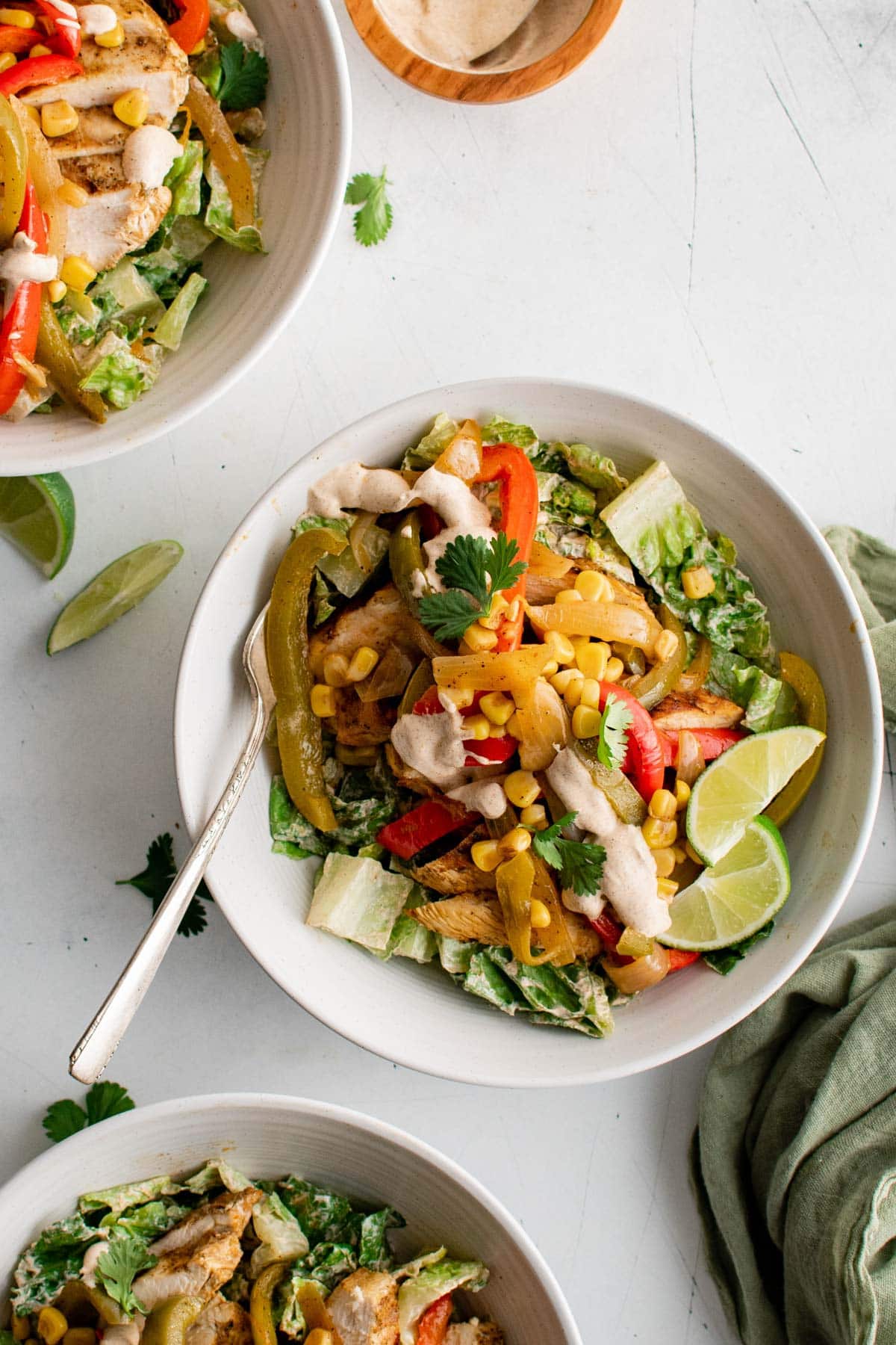 Chicken fajita salads in white serving bowls.