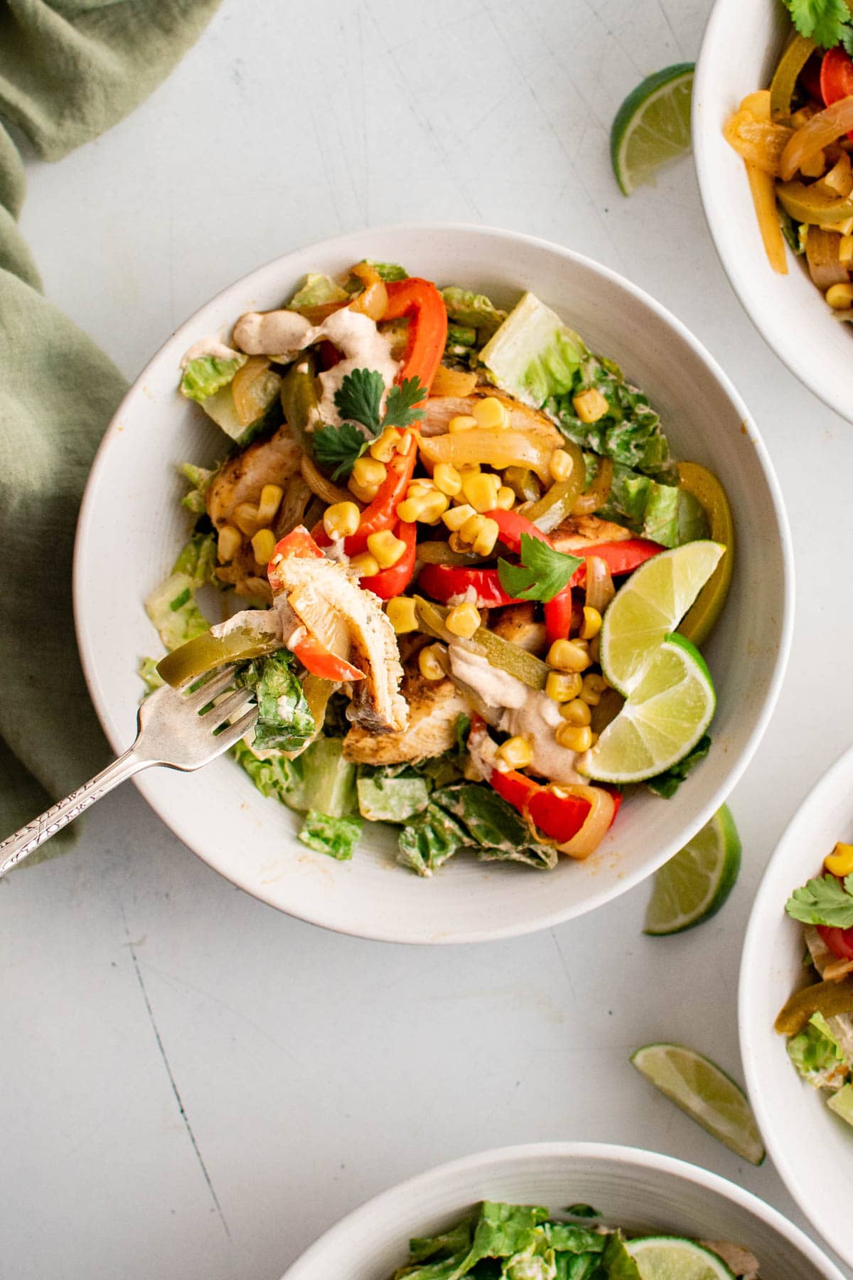 Chicken fajita salad in a white bowl.