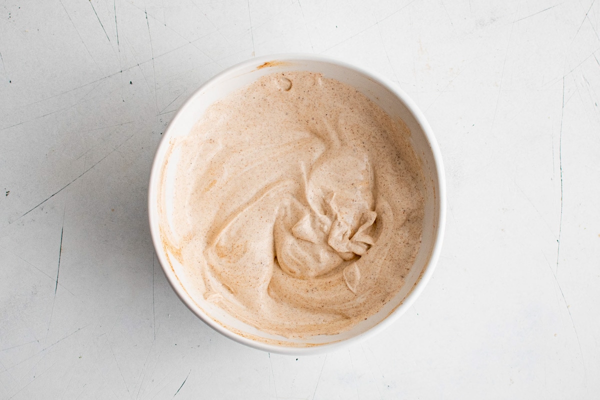 Sour cream and chili powder dressing in a white bowl.