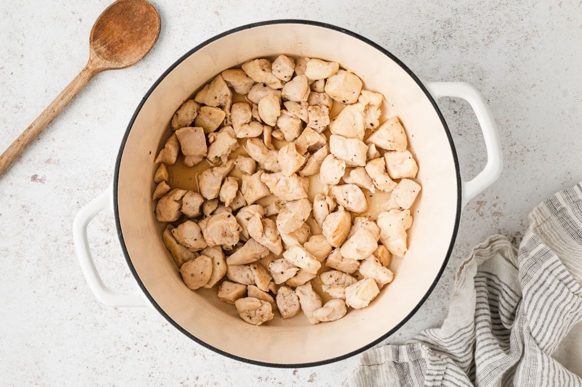 Pieces of cooked chicken breasts in a large pot.