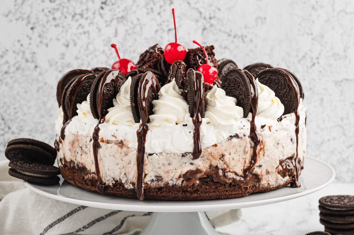 Oreo ice cream cake with cookies and cream ice cream, whipped topping and cherries.