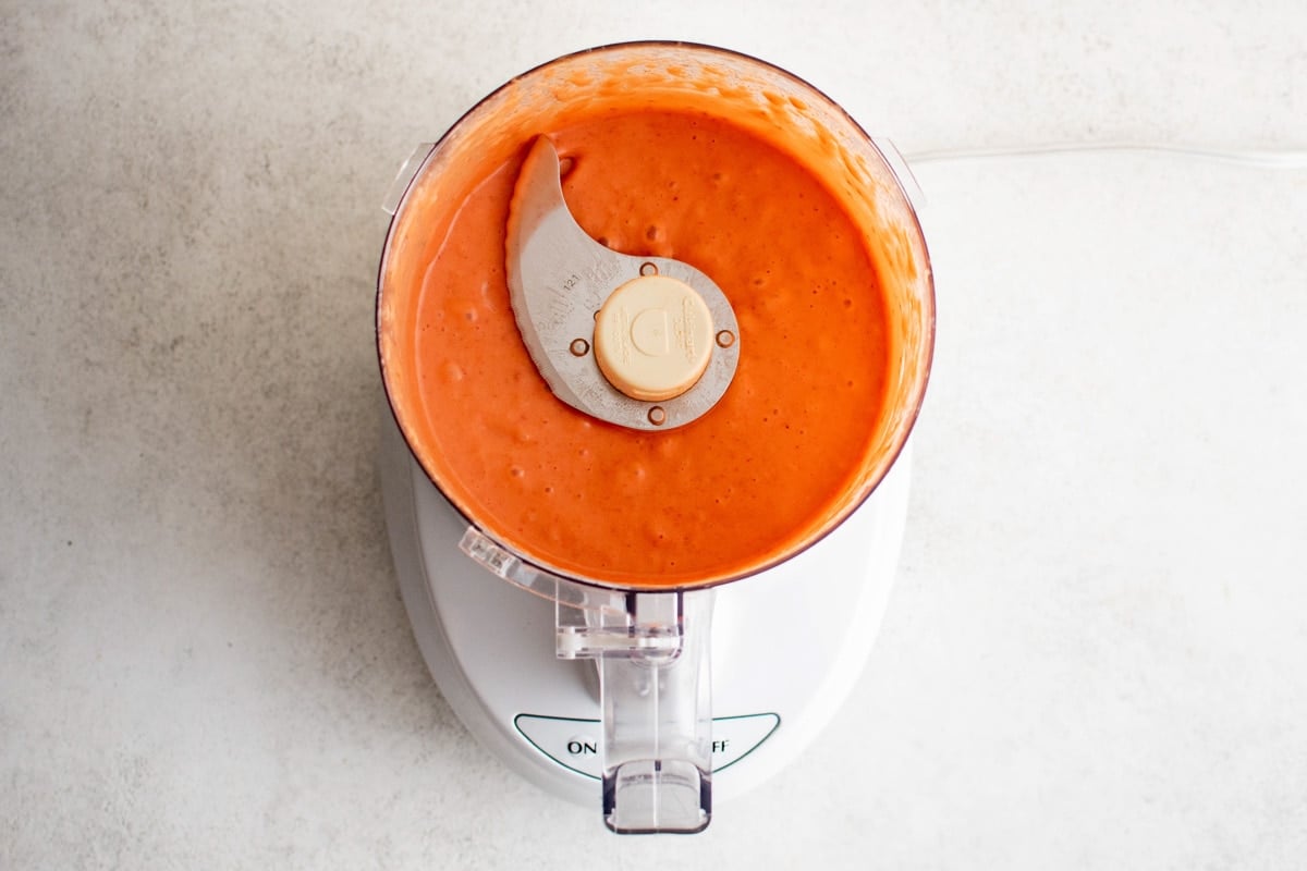 Food processor with blended raspberry vinaigrette.