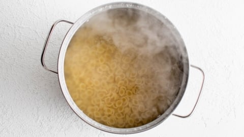 Pasta cooking in boiling water in a large pot.