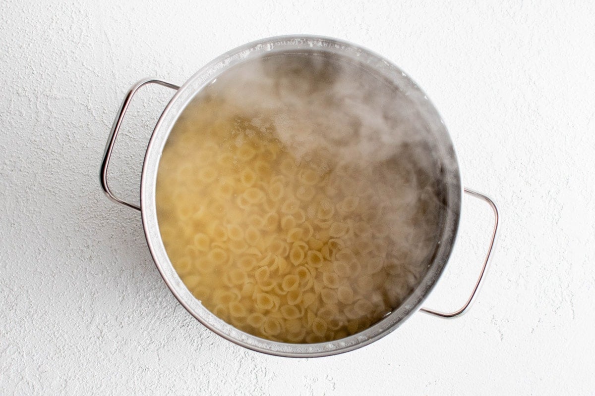 Pasta cooking in boiling water in a large pot.