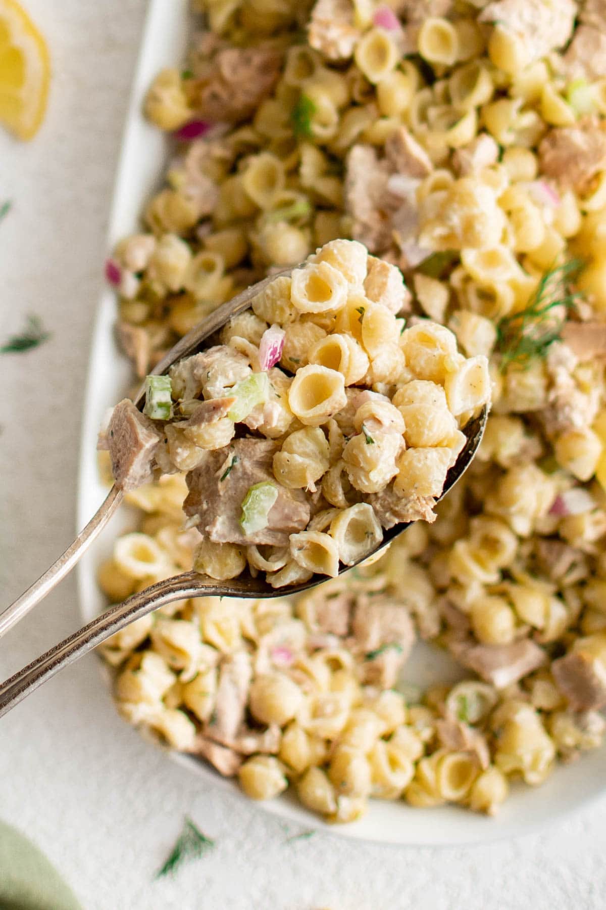 Tuna Pasta Salad: perfect for picnics or potluck, lunch or dinner | Healthy meal idea | Side Dish | Weeknight dinner tuna pasta salad with metal serving spoons.