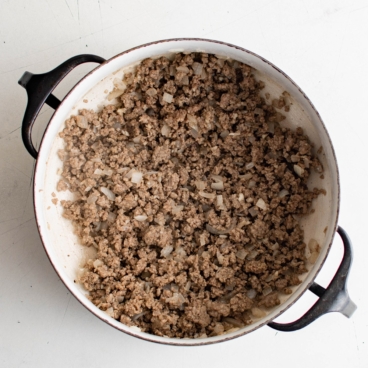 Ground beef cooked with onions in a pan.