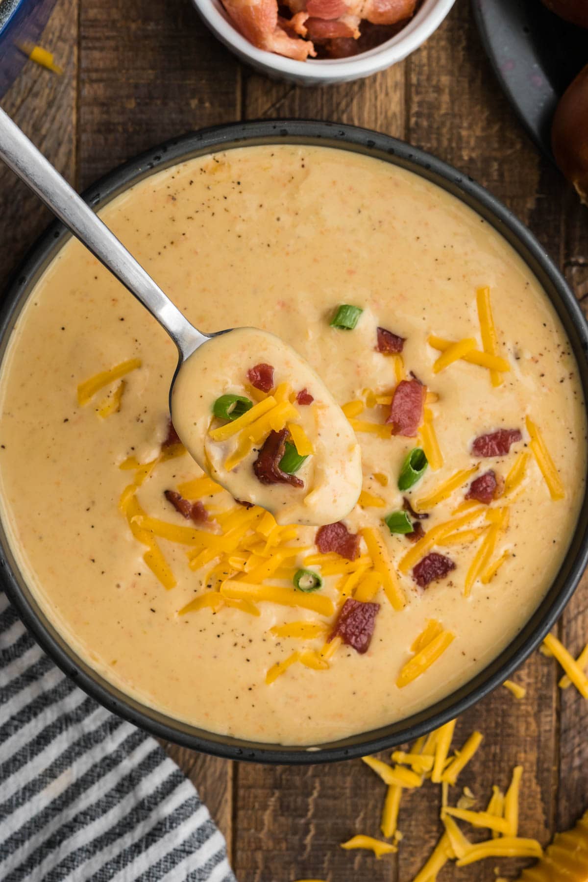 Beer cheese soup in a bowl with a spoon.
