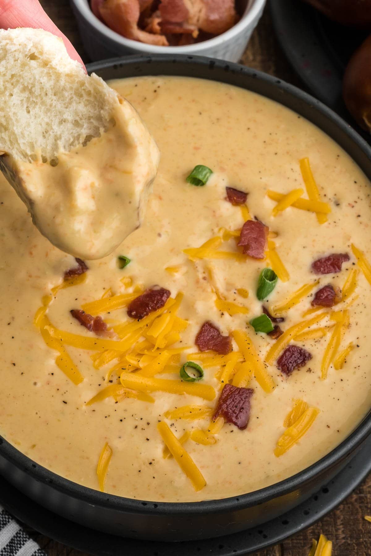 A small piece of bread dipped into beer cheese soup.