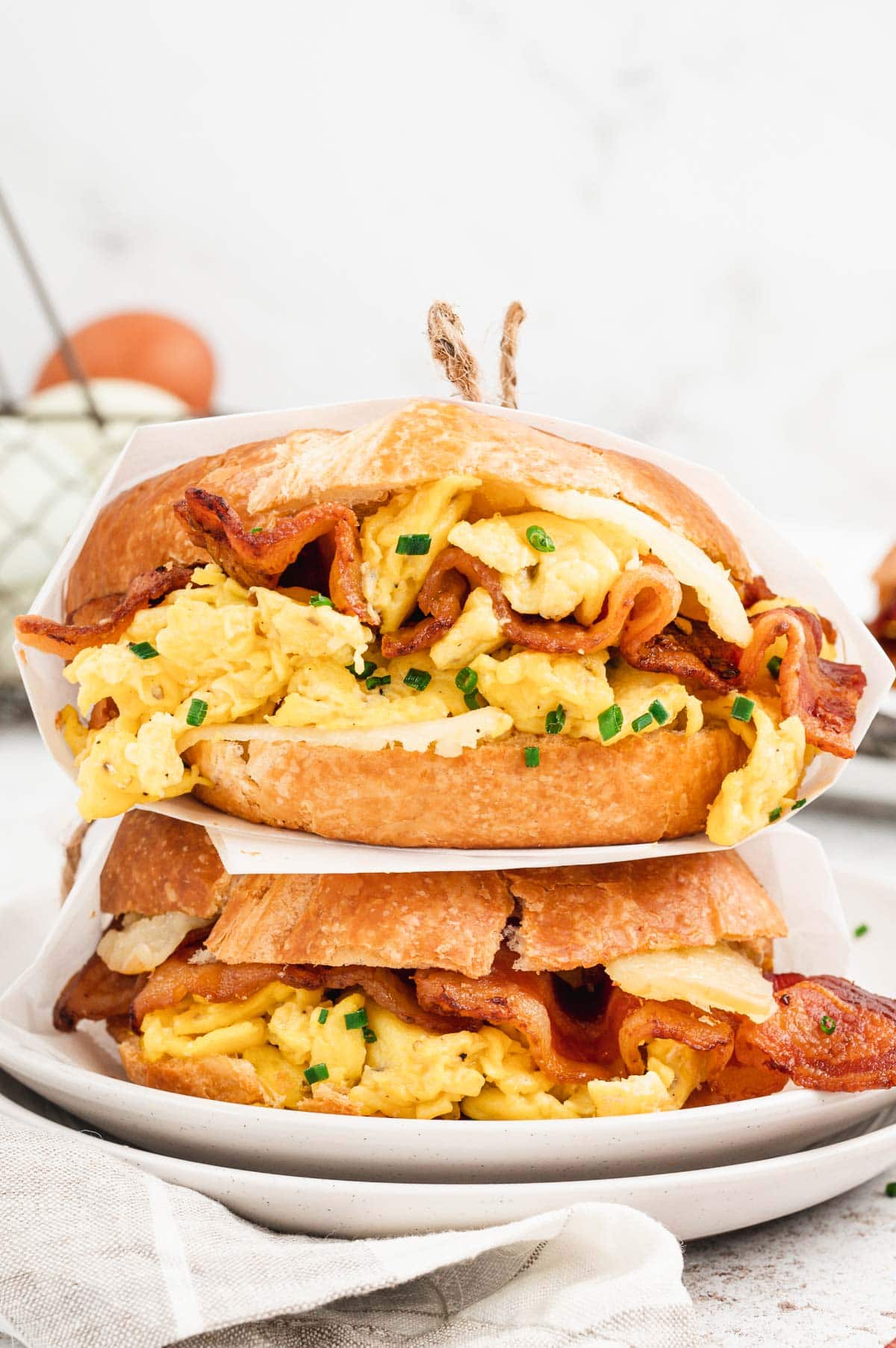 Two stacked croissants with scrambled eggs, bacon and chives.