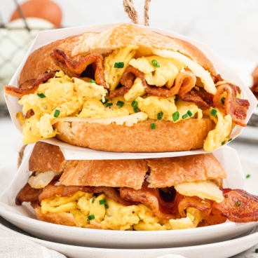 Breakfast croissant sandwiches stacked on top of each other.