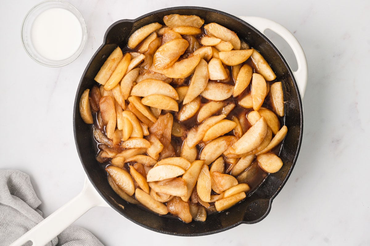 Caramelized apples in a large black skillet.