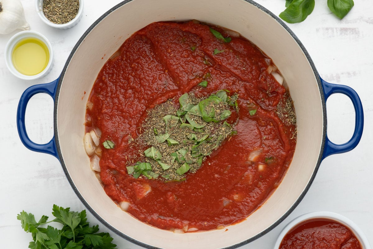 Diced onion, crushed tomatoes, italian seasoning and fresh basil in a large dutch oven.