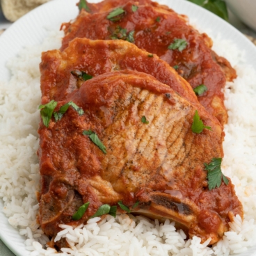 pork chops with tomato sauce over rice.