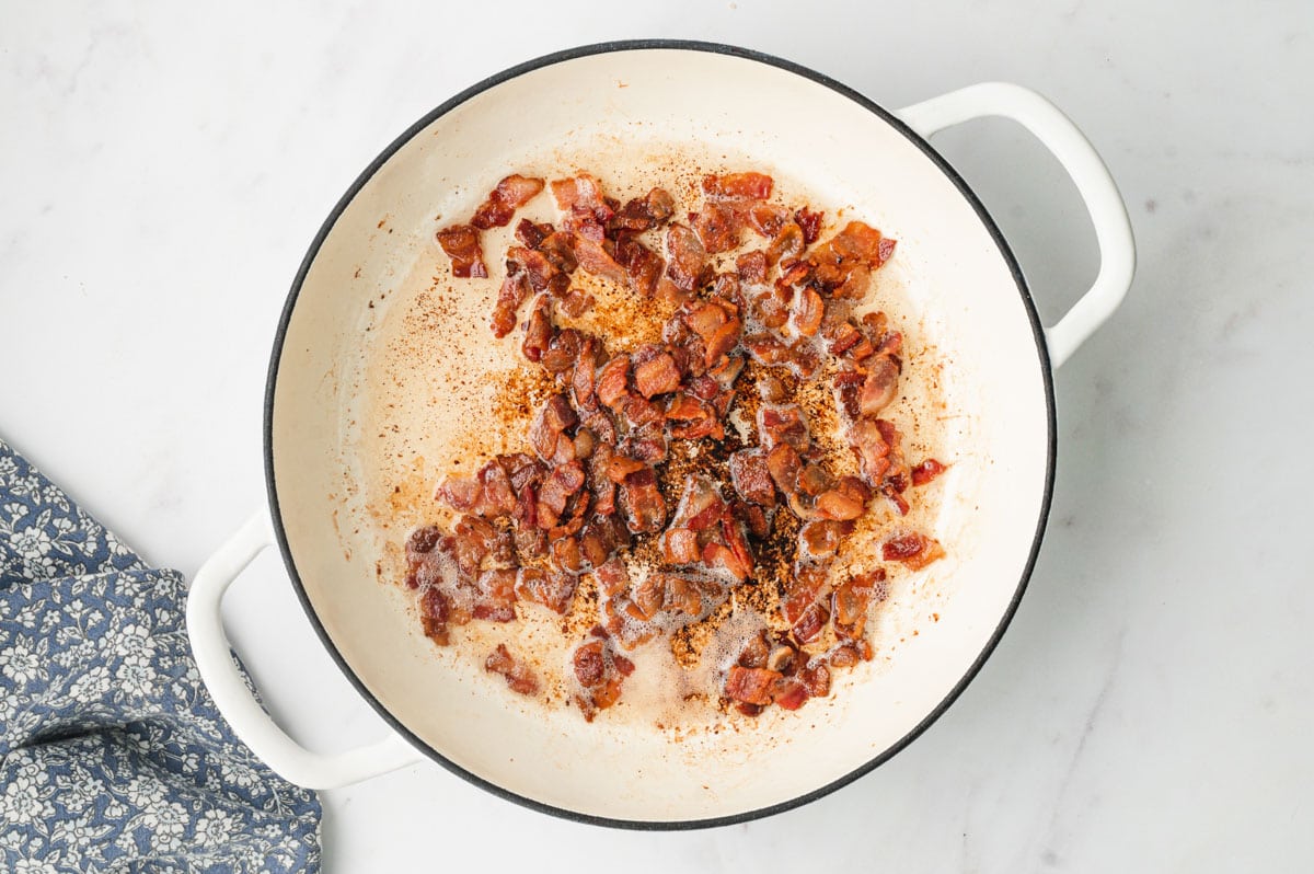 Crisp bacon cooking in a skillet.