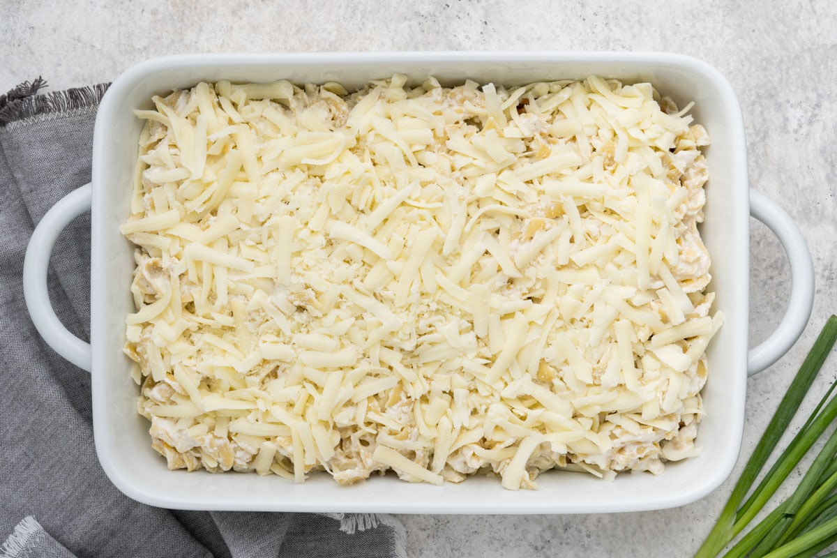 Lots of shredded mozzarella in a casserole dish.