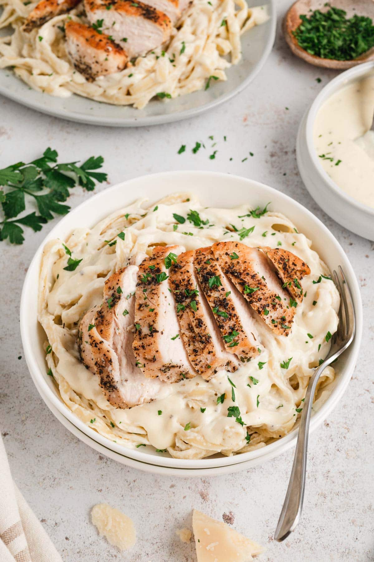 Fettuccine noodles with alfredo sauce and chicken in a serving bowl