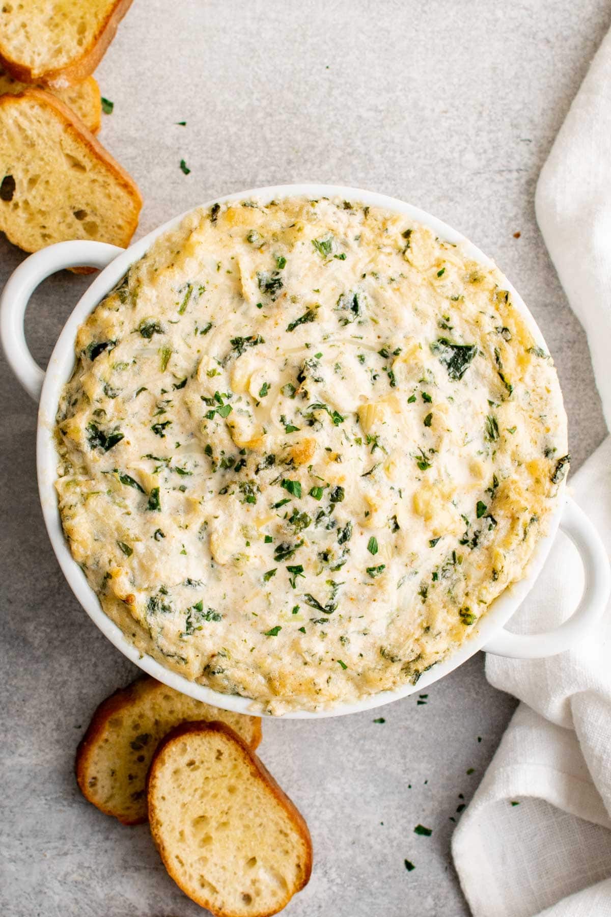 Baking dish with hot crab artichoke dip, crostini.