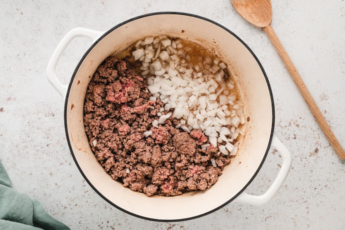 Cooked ground beef, diced onions in a dutch oven.