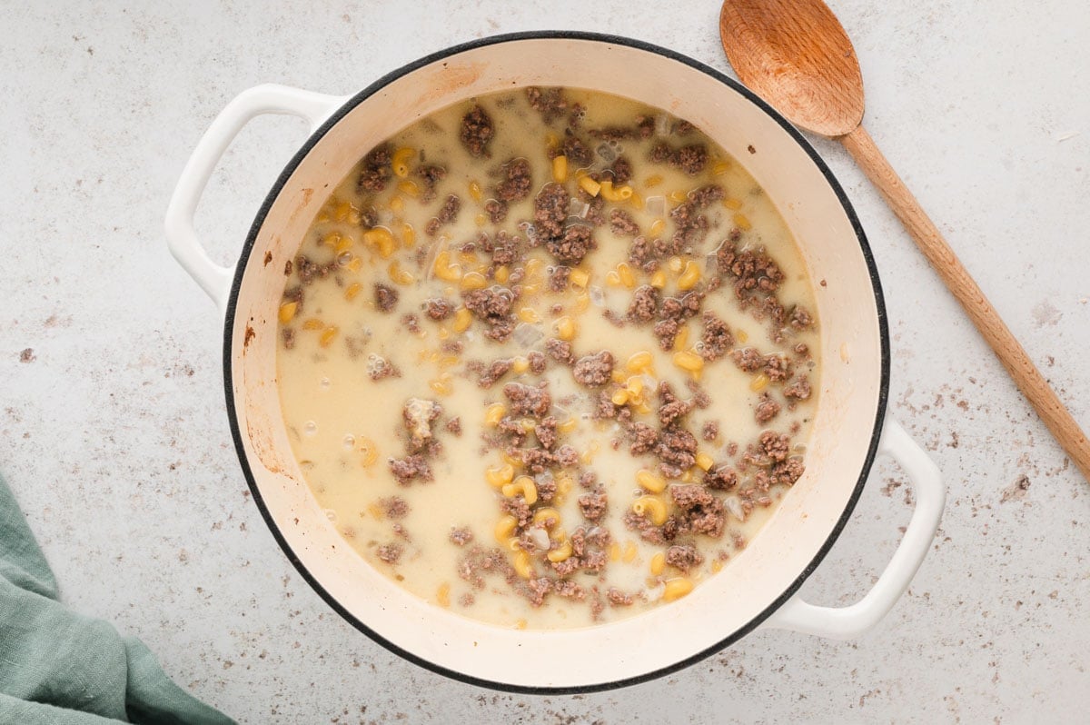 Ground beef, uncooked macaroni, milk and broth in a large soup pot.
