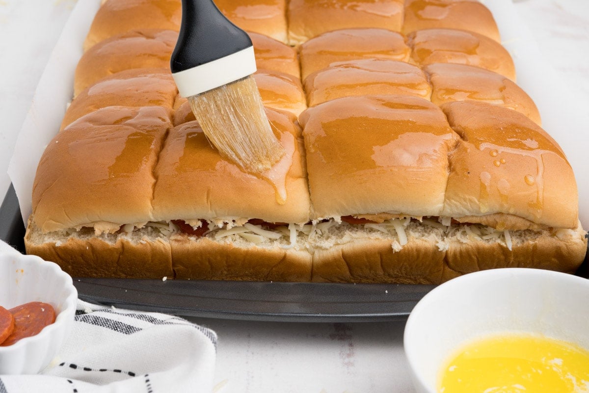 Hawaiian rolls with a pastry brush and melted butter.