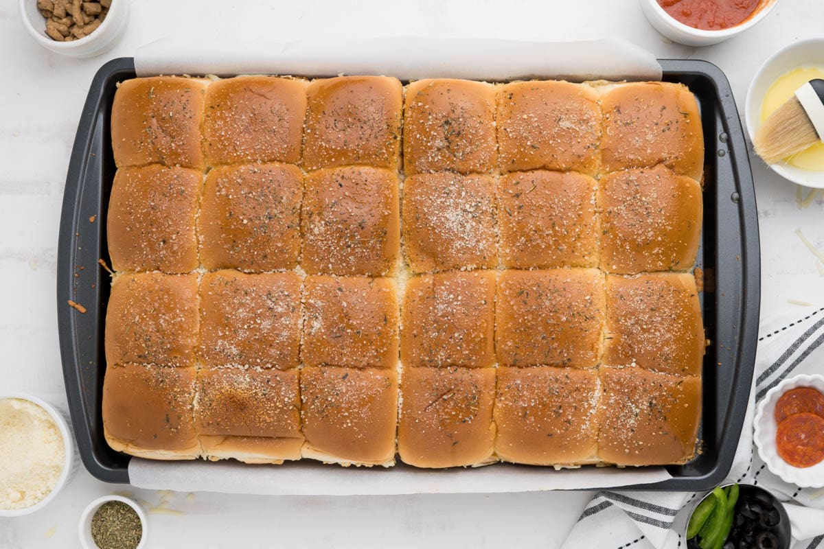 Top view of slabs of sliders with parmesan and seasoning.