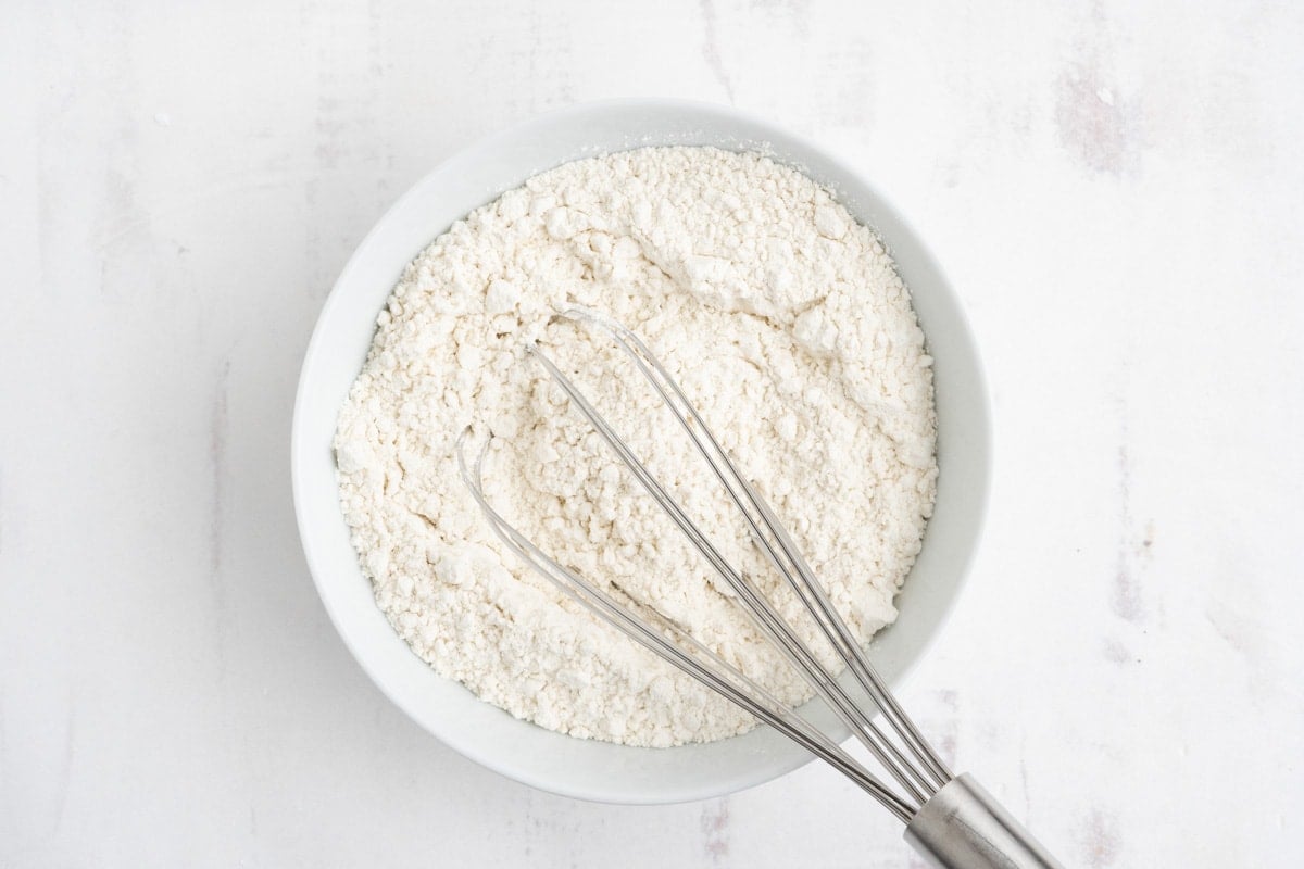 Flour in a big bowl with a whisk.