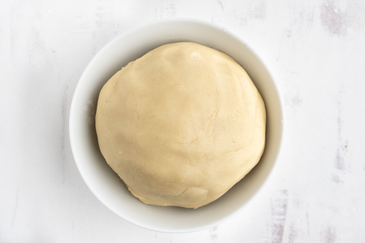 Large ball of cookie dough in a white bowl.