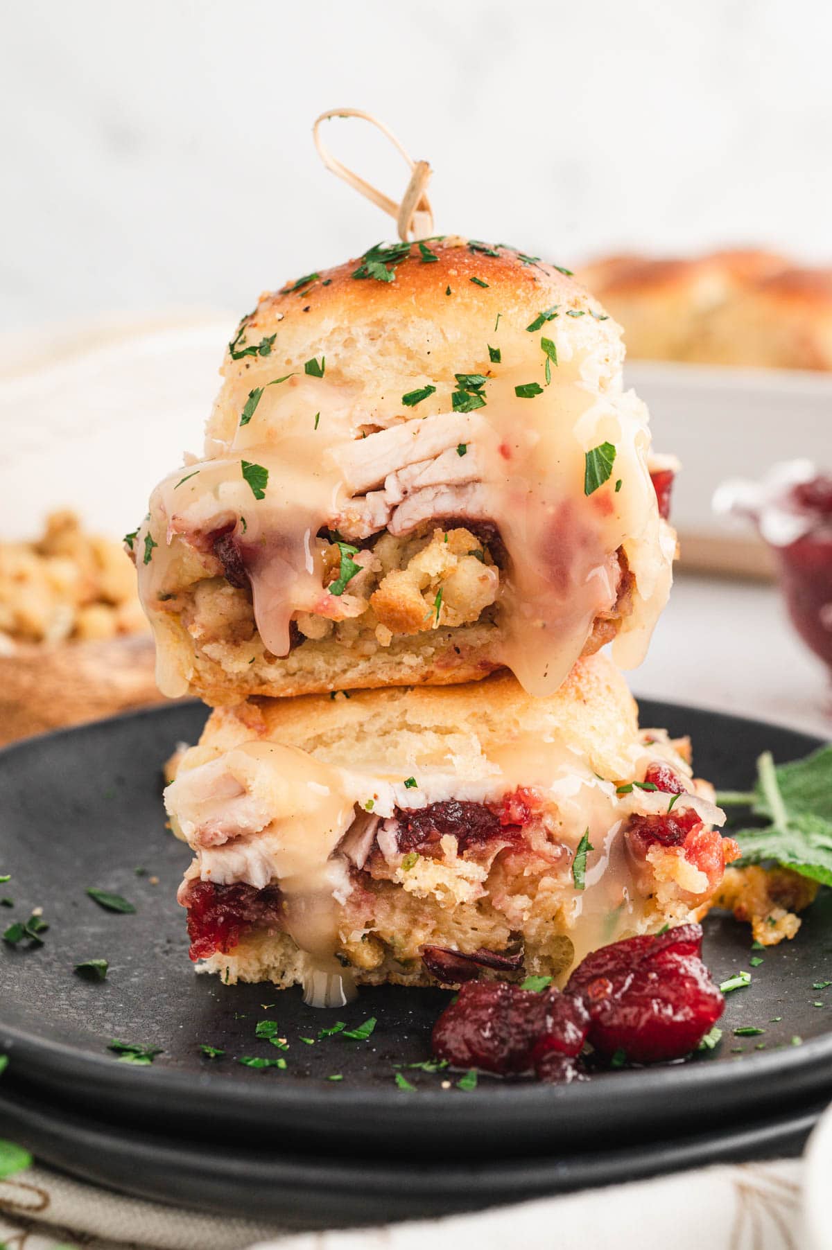 Two sliders with turkey, cranberry and stuffing stacked on top of each other.