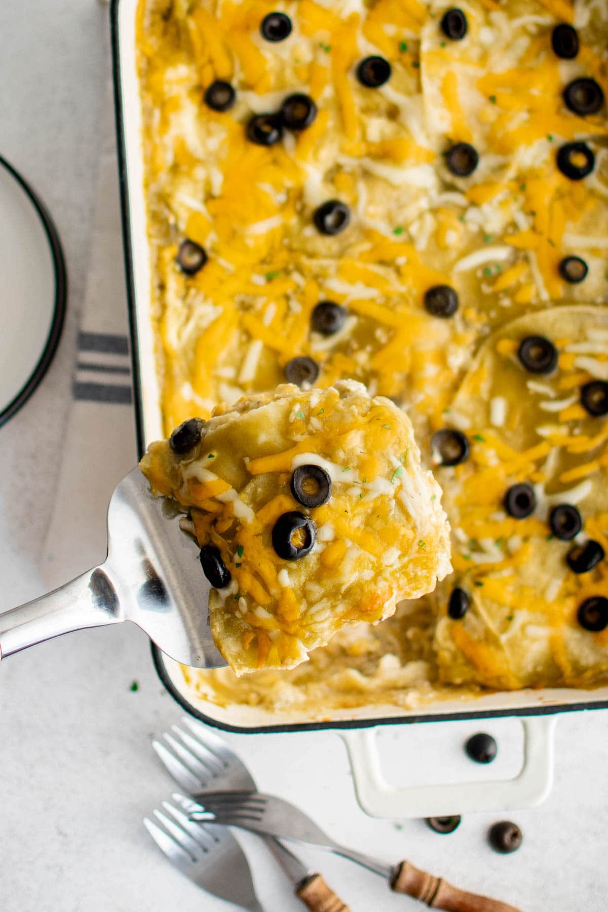 Chicken Enchilada Casserole with green sauce, cheese and olives.