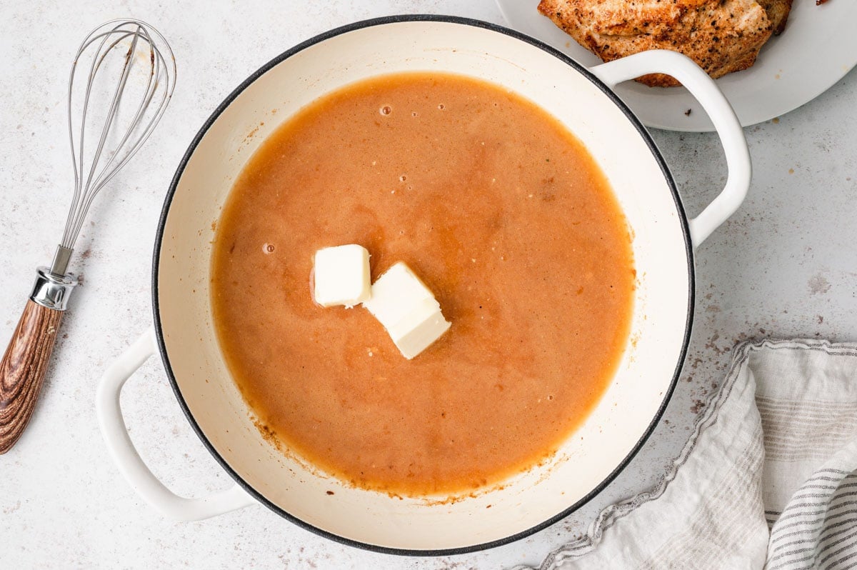 Brown sauce with a couple of pats of butter in a large cream colored skillet. 