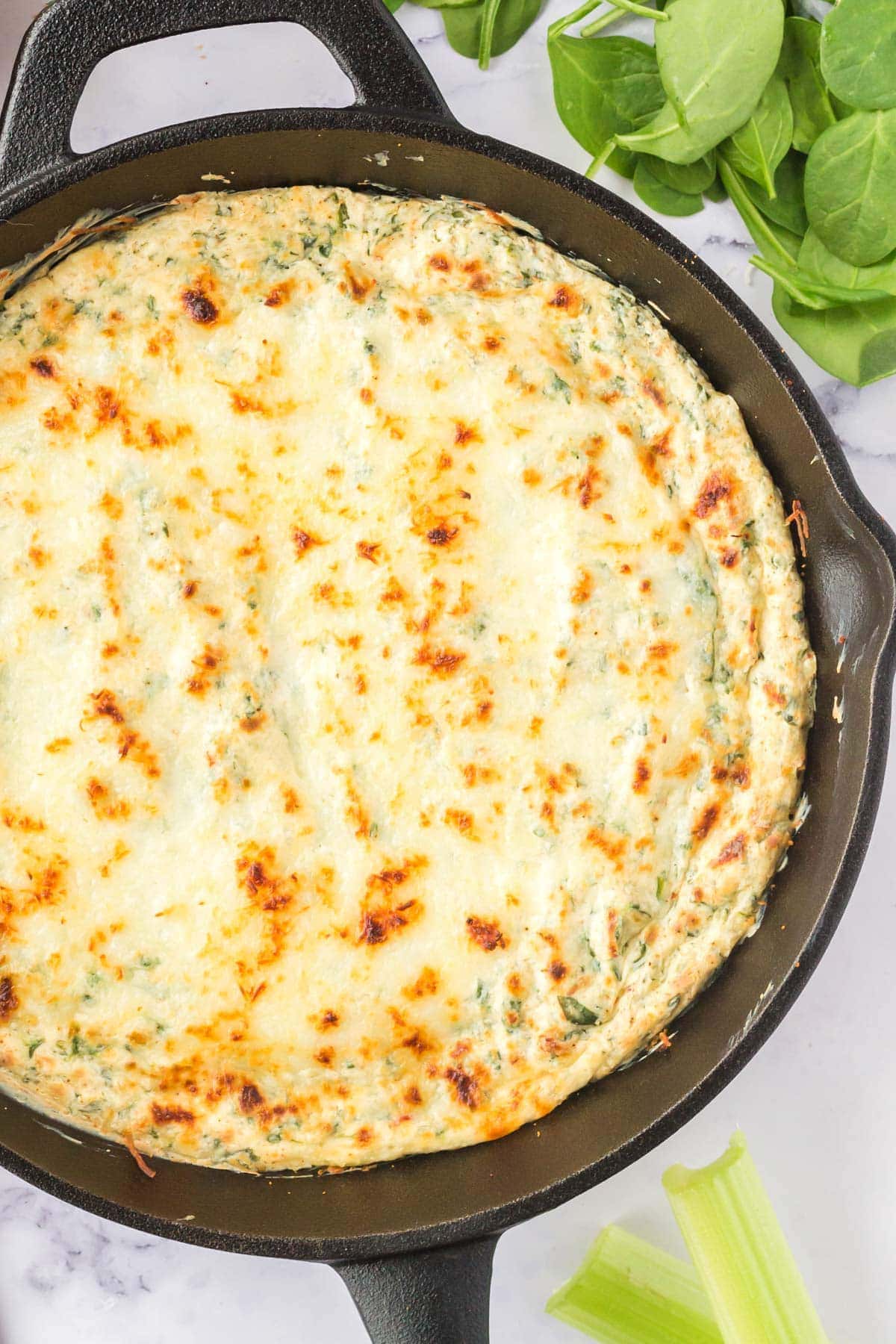 hot spinach dip in a cast iron skillet