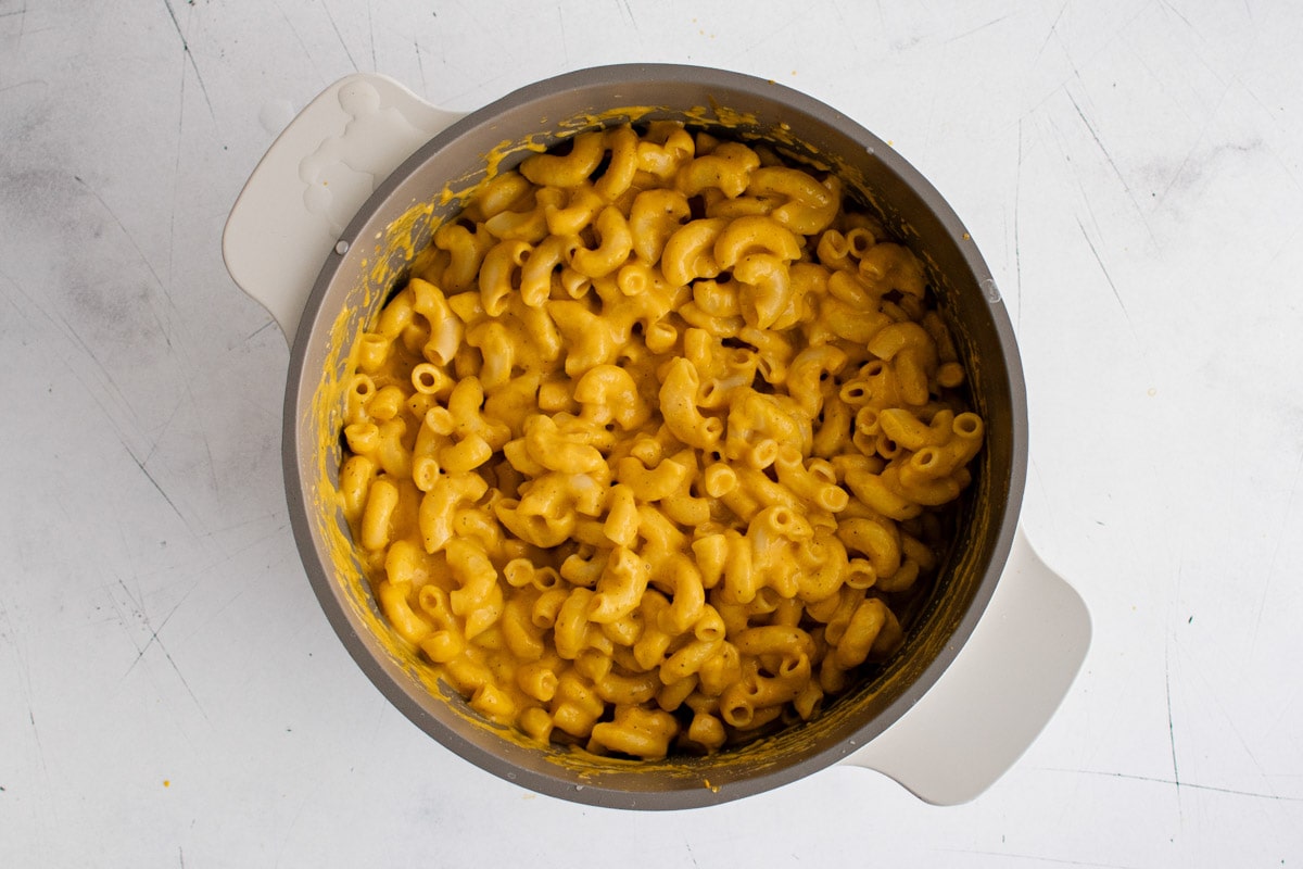 Macaroni with a pumpkin cheese sauce in a sauce pan.