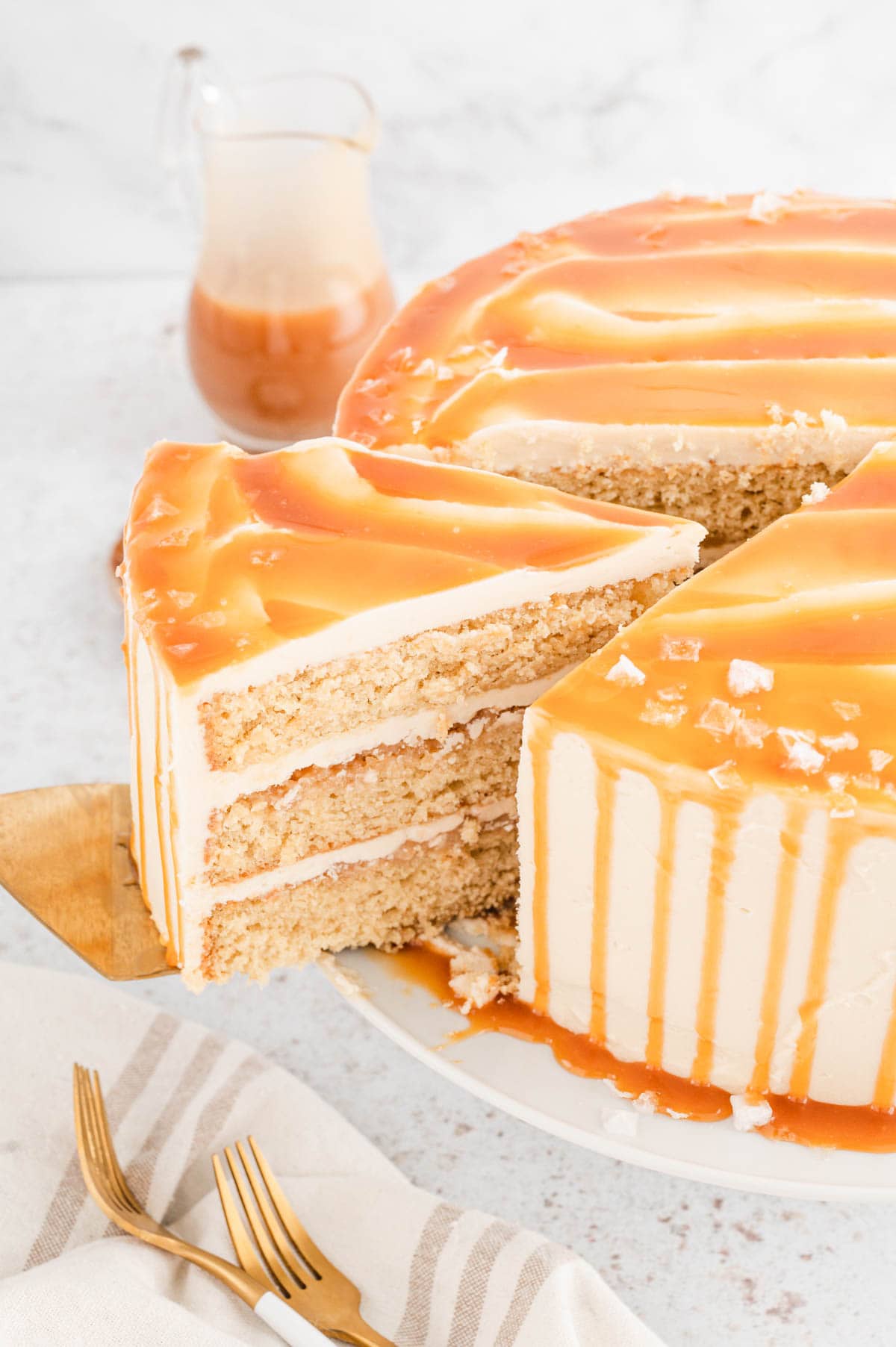 Caramel cake with a slice being removed.